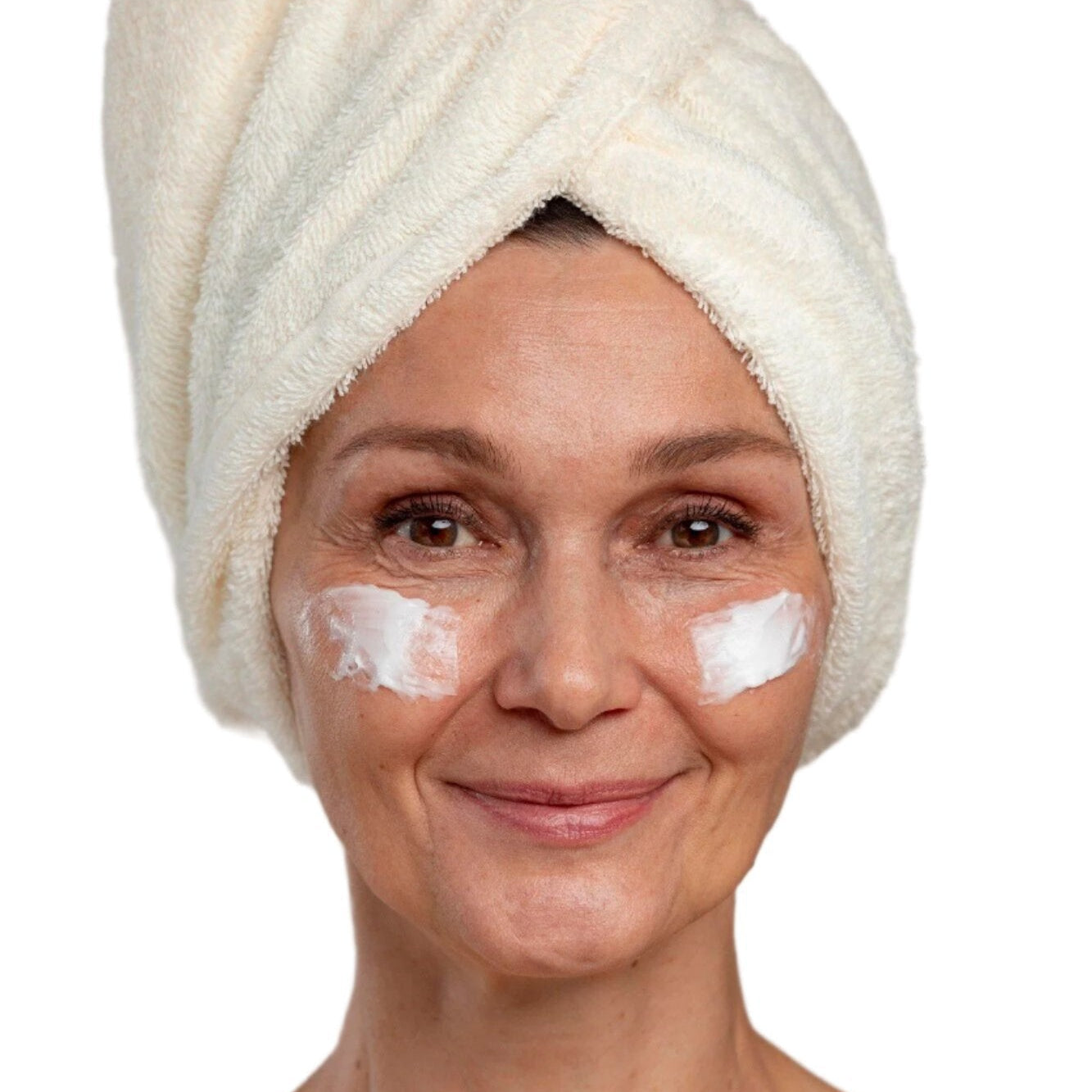 White woman in white head towel with face cream on cheeks. Best anti-aging face cream. Dermal Essentials Medical Grade Skincare.