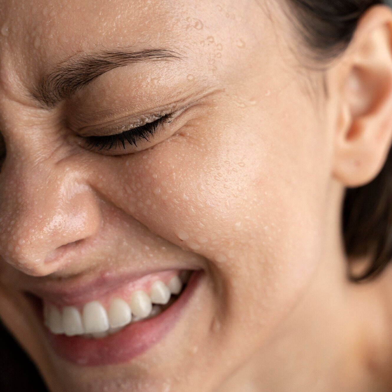white woman using Boost: A Solution mist on their face for hydration and relief.