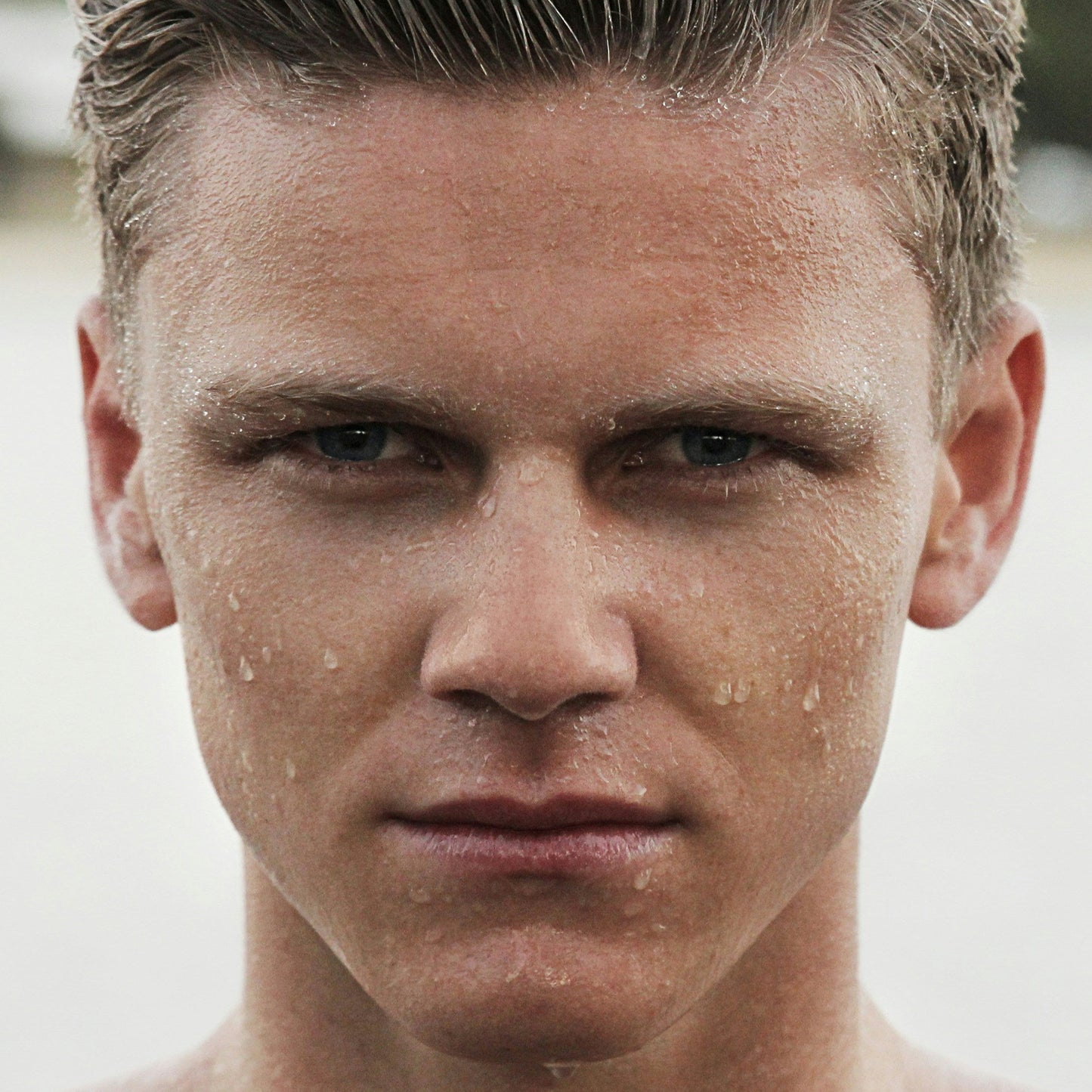 white male using Boost: A Solution mist on their face for hydration and relief.