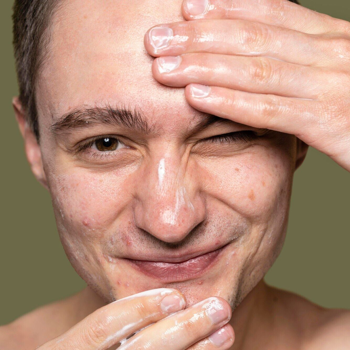 A person applying Clarify: A Cleanser to the face