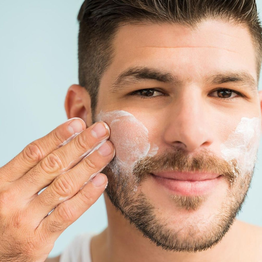 white man brown hair and beard applying best oil free moisturizer to face. dermal essentials medical grade skincare.