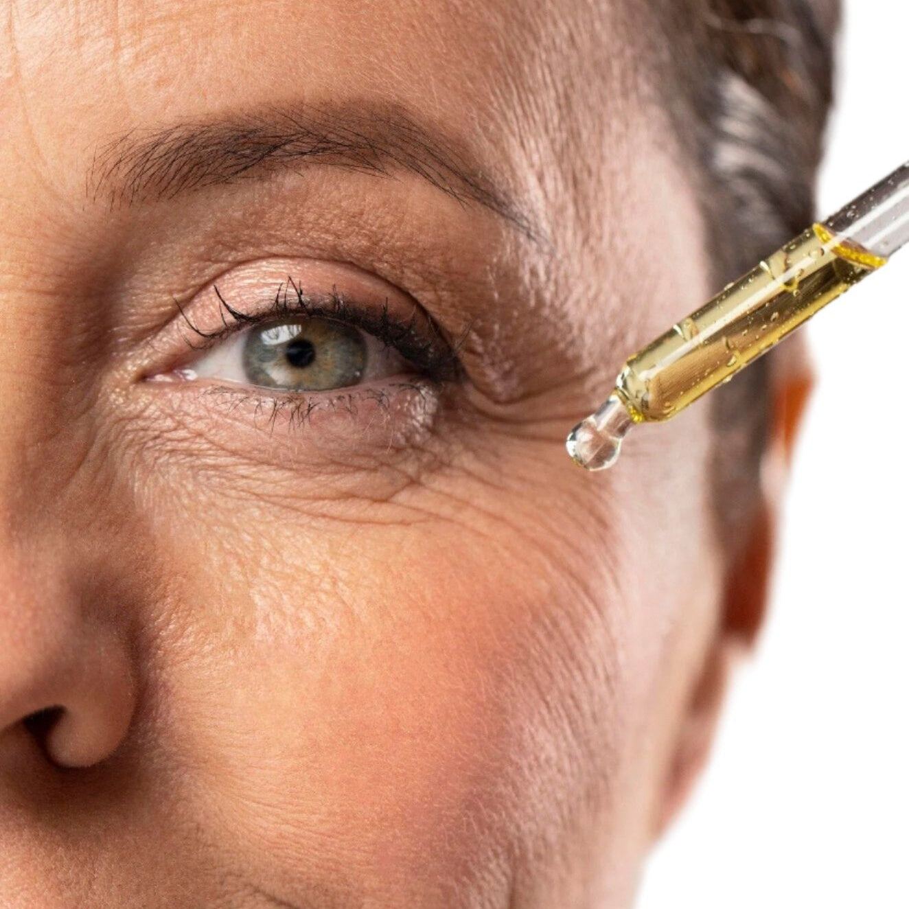 White woman with clear dropper applying best vitamin c serum for face with vitamin e and ferulic acid. Dermal Essentials Medical Grade Skincare.