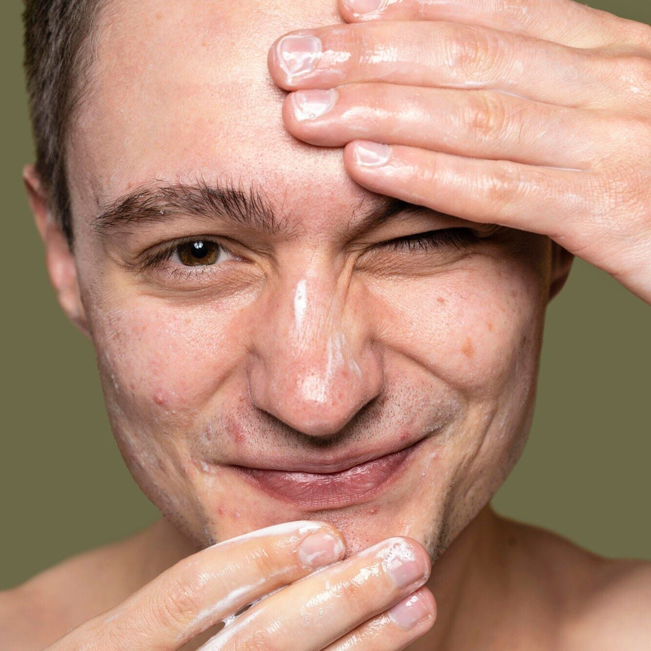white young man applying facial cleanser dermal essentials medical grade skincare