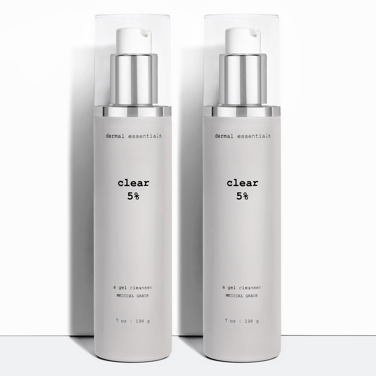 Two Silver cylinder plastic bottles black letters silver and white plastic pump clear white lid 7 fl.oz. Clear 5% benzoyl peroxide acne facial cleanser Dermal Essentials Medical Grade Skincare