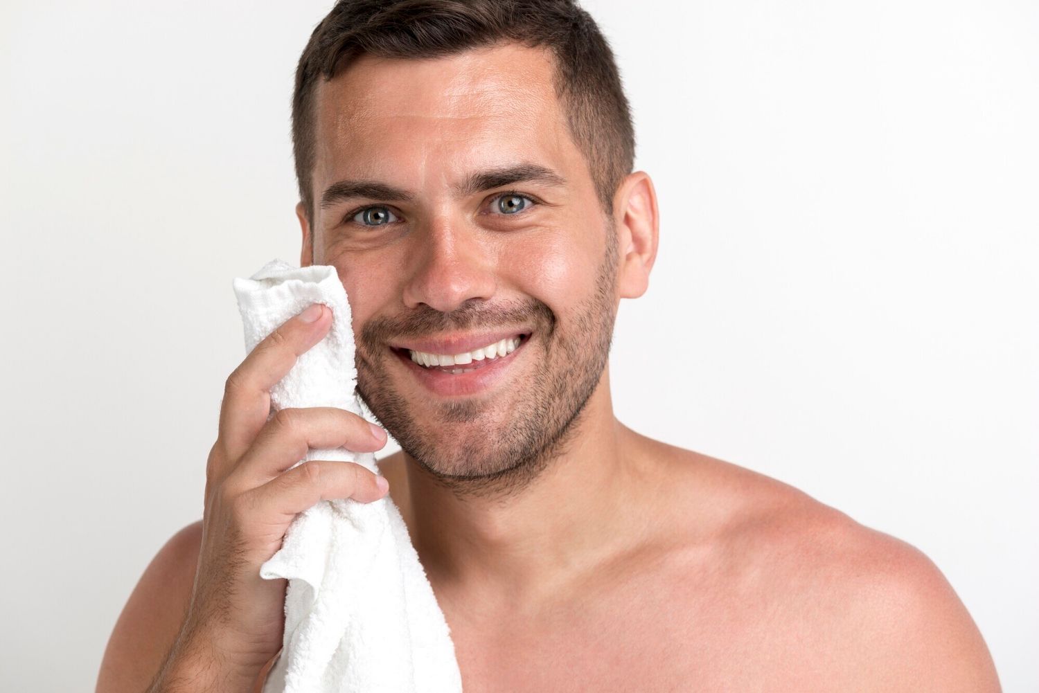 White man brown hair white towel in hand. Best anti-aging serum for face. Dermal Essentials Medical Grade Skincare.