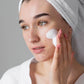 white woman white head towel white hand applying white acne cleanser dermal essentials medical grade skincare