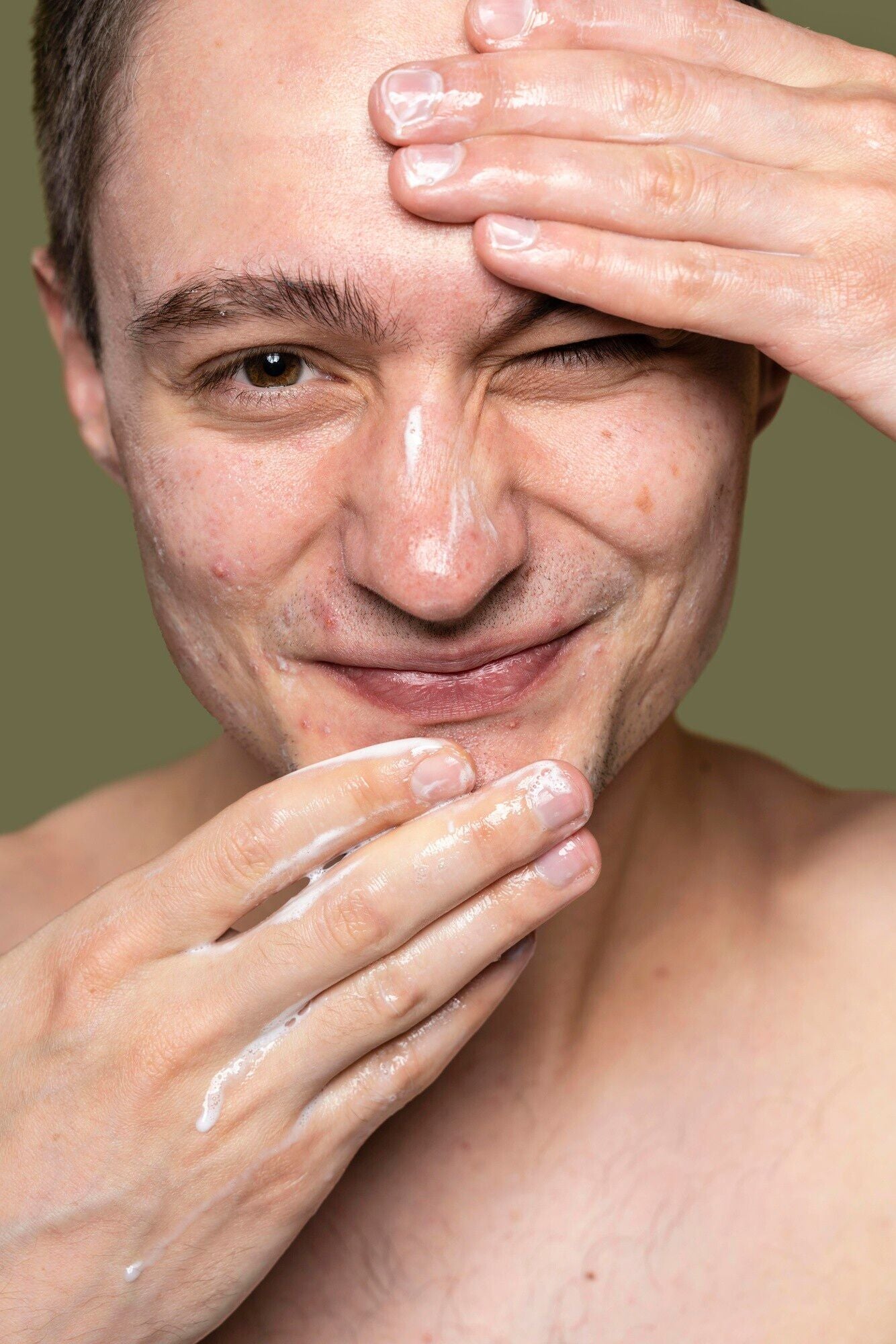 white young man applying facial cleanser dermal essentials medical grade skincare